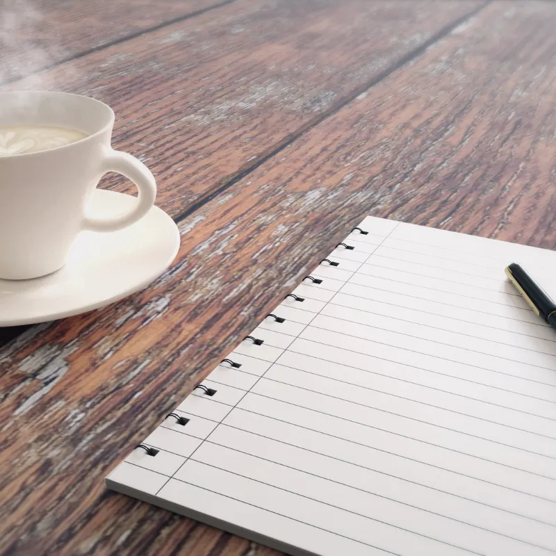 Carnet ligné et tasse de café sur une table en bois